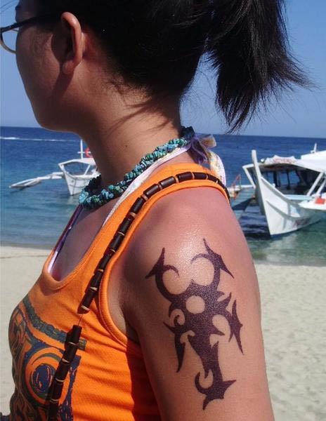 A very aggressive tribal scorpion tattoo displayed prominently on the upper